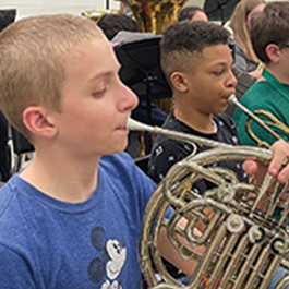 two male students playing brass musical instruments